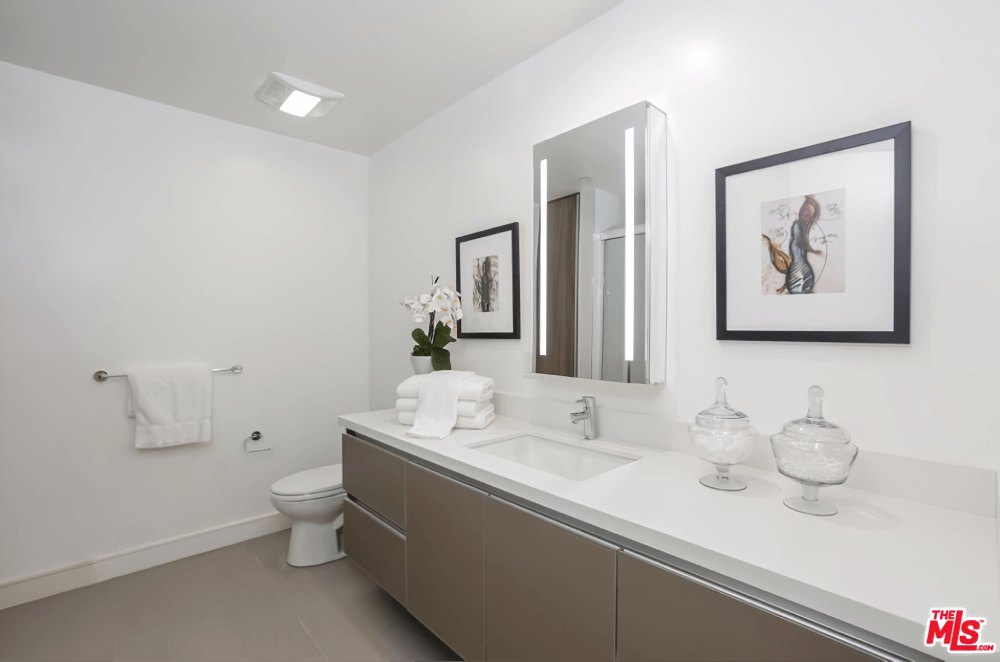 Guest bathroom with framed art and stone counter at Olympic Towers