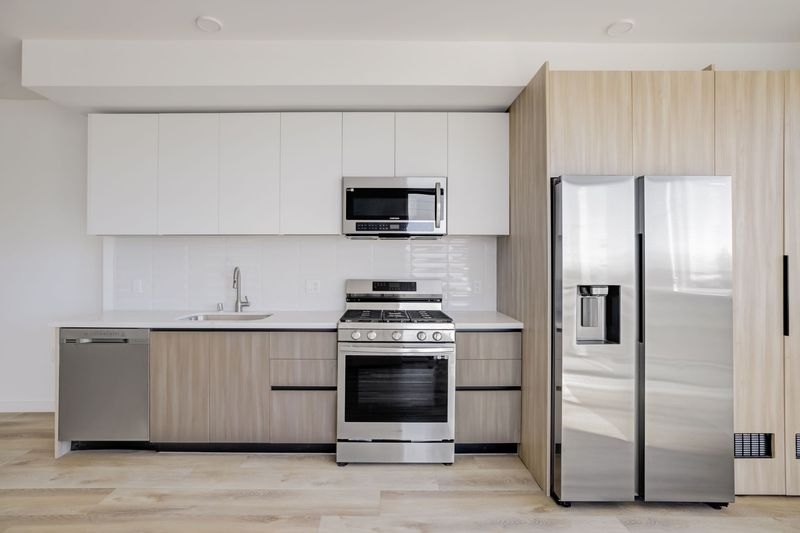 Modern kitchen with light wood cabinetry at The Felix on Fairfax